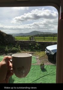 a person holding a cup in front of a window at The Views in Church Stretton