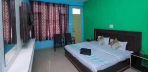 - une chambre avec un grand lit et un mur vert dans l'établissement Mcleodganj Diaries Homestay, à Dharamshala