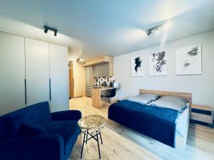 a bedroom with a blue bed and a couch at Loftowe Love in Kołobrzeg +13 photos