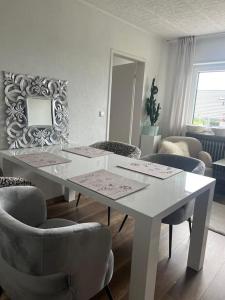 a white dining room with a white table and chairs at Ferienwohnung Firmenwohnung Nähe Maulbronn Badesee in Ölbronn-Dürrn +5 photos