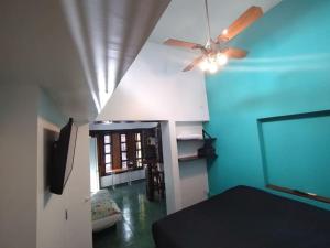 a room with a ceiling fan and a living room at Pintoresco departamento full equipado in Buenos Aires