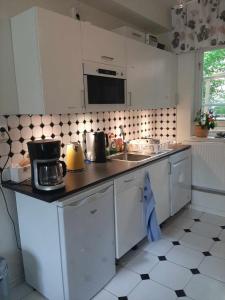 a kitchen with white cabinets and a counter top at Villa Kungssten in Gothenburg