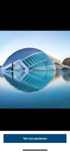 a person standing in front of a building on the water at Apartamentos Bulevar in Valencia
