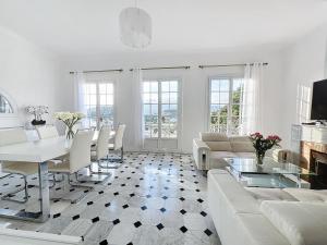 een woonkamer met een witte bank en een tafel bij Amazing view villa for your holidays in Villeneuve-Loubet