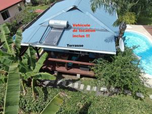 a building with a sign on it next to a swimming pool at bungalow chez sofpat in Uturoa