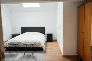 a bedroom with a bed and two chairs in it at The nestie in Walhain-Saint-Paul
