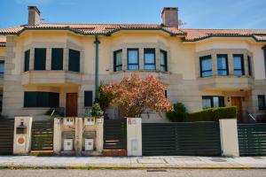 una casa con una valla delante en Exclusiva casa en playa América, cerca de Baiona, en Nigrán