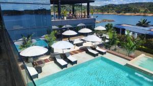 瓜塔佩的住宿－Vivanti Resort，一座带遮阳伞和椅子的游泳池位于一座建筑旁边