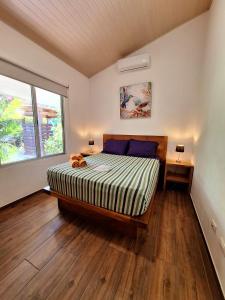 um quarto com uma cama grande e uma janela em Alloro Jungle Villas em Puerto Viejo