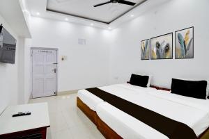 um quarto branco com uma cama grande e um tecto em OYO Orchid Guest House em Durgapur
