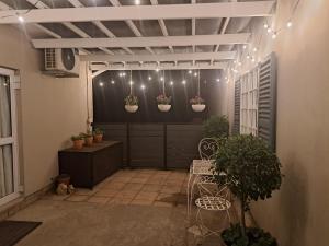 a patio with potted plants on a wall with lights at Ceres Cozy Cottage in Ceres