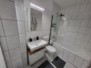 een witte badkamer met een wastafel en een toilet bij Zentrumsnahe Wohlfühloase in Kassel +8 foto's