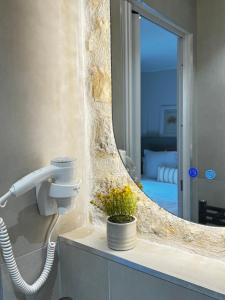 a bathroom with a hair dryer and a mirror at Hotel Paris Amore in Paris