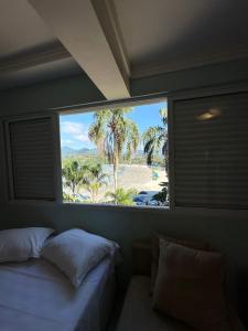 a bedroom with a window with a view of a beach at Mansão Tenório in Ubatuba +102 photos