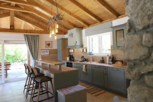 a kitchen with gray cabinets and a bar with stools at Villa Ulikva in Malinska