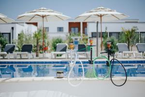 a pool with chairs and umbrellas next to a swimming pool at Imperial Family Bungalows in Ulcinj