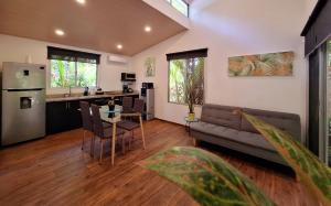 a living room with a couch and a table and a kitchen at Alloro Jungle Villas in Puerto Viejo