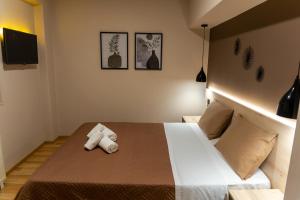 Un dormitorio con una cama con una toalla. en NOVOS guesthouse Meteora, en Kalambaka