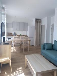 a living room with a blue couch and a kitchen at V.KLS Appartement 3 in Languidic