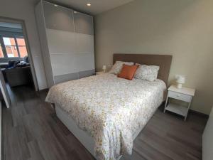 a bedroom with a bed with an orange pillow on it at Apartamento acogedor en La Camocha-Gijón in Monte de Huerces