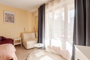 a bedroom with a bed and a window with a chair at Studio central Brides-les-Bains in Brides-les-Bains