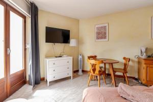 a bedroom with a table and a tv and a bed at Studio central Brides-les-Bains in Brides-les-Bains