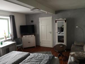 a bedroom with a bed and a tv and a couch at Apartment am Stadtturm in Freyburg