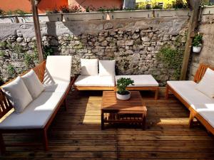 a patio with couches and a table and a stone wall at Casa di Volce - 1801 Stone House in Tolmin