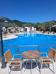 uma vista para uma piscina com uma mesa e cadeiras em Ocean Beach Hotel em Skala Potamias
