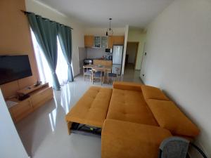 a living room with a brown couch and a kitchen at Nifa House in Espargos