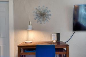 a desk with a blue chair and a clock on the wall at #StayinMyDistrict Heritage House Pet Friendly Apartment in Coos Bay +52 photos