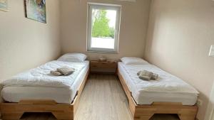 two twin beds in a room with a window at Ferienwohnung am Gurkenradweg in Werben