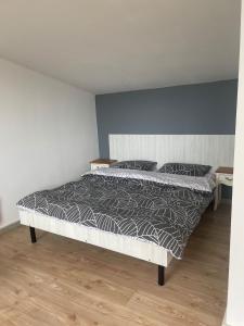 una camera da letto con un letto con un piumone grigio e bianco di Casa Ryana Gilau a Gilău
