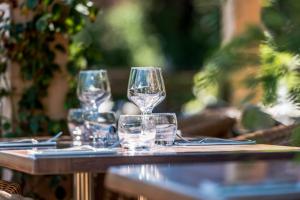 four wine glasses sitting on top of a table at L'Arcalod Hôtel Restaurant & Spa in Doussard