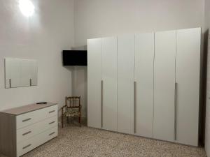 a bedroom with a white cabinet and a dresser at Casa Bel Duomo in Gerace +15 photos