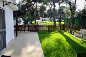 a wooden fence in a yard with green grass at Bungalow Fatamorgana in Pulsano