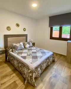 a bedroom with a bed with a checkered blanket at El Hondón del Lugar in Hoyos