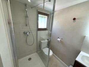 a white bathroom with a shower and a toilet at L'Escale aux portes des Gorges de l'Ardèche in Saint-Martin-dʼArdèche