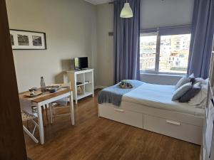 una camera con letto, scrivania e finestra di Oporto Trindade Residence a Porto