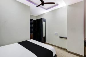 1 dormitorio con 1 cama y ventilador de techo en OYO AADYA INN, en Tirupati