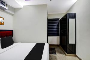 1 dormitorio con 1 cama y armario negro en OYO AADYA INN en Tirupati