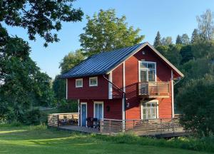 een rood huis met een zwart dak bij Sea Side Cabin in Borlänge