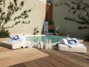 a swimming pool with two mattresses and towels in front of it at The Pelican Beach Resort & SPA - Adults Only in Olbia