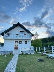 una casa blanca con una valla delante en White Home, en Žabljak
