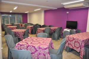une salle de conférence avec des tables, des chaises et une télévision dans l'établissement Hotel Holiday, à Nigrán