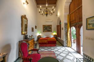 un soggiorno con un letto e un lampadario di Ryad Mabrouka a Fes