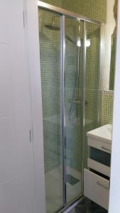 y baño con ducha y puerta de cristal. en La LLastrina 14A03, en Lastres