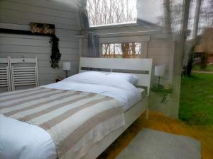 a bedroom with a large white bed and two windows at Sterrenzicht BB Weidszicht in Doezum