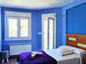 - une chambre bleue avec un lit et 2 fenêtres dans l'établissement López Estación, à Sarria