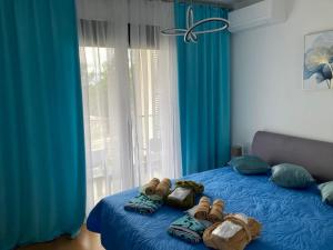 a bedroom with a blue bed with shoes on it at Sears Residence Apartments in Tivat